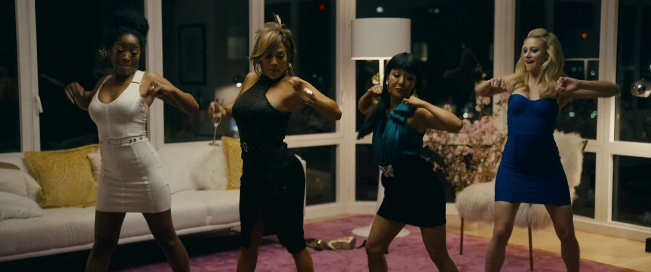 Hustlers (2019) movie still: fullbody — An upscale modern apartment features large floor-to-ceiling windows overlooking a dark city at night. Four…
