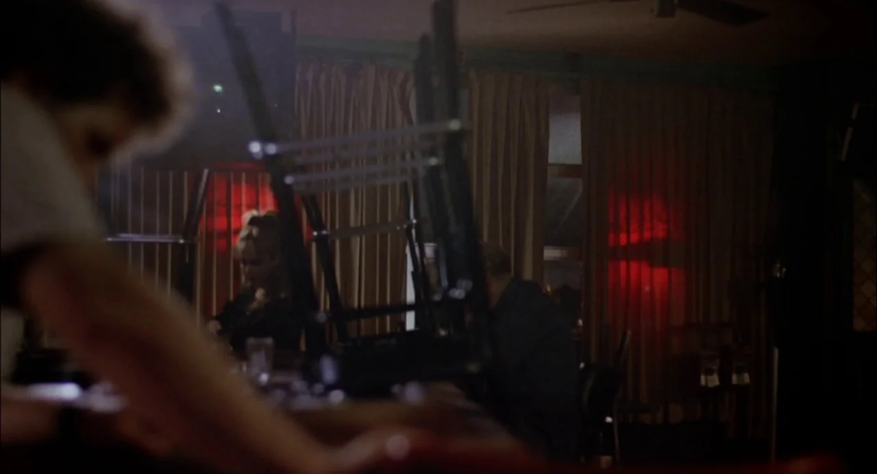 Trees Lounge (1996) movie still: medium — A dimly lit bar interior features closed curtains accented by prominent red neon lights. A man sits at the…