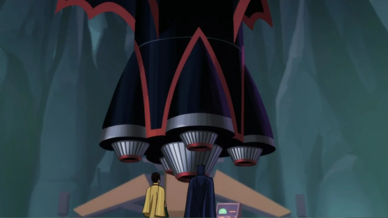 Batman: Return of the Caped Crusaders (2016) movie still: wide — A subterranean hangar contains a large dark rocket with red trim standing…