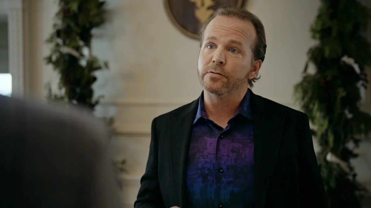 Christmas in Washington (2003) movie still: medium — An interior space features pale walls decorated with holiday greenery and a wall plaque. A man…