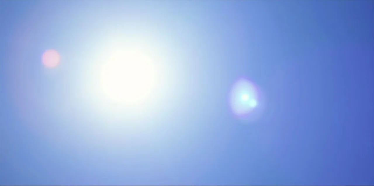A Radical Life (2022) movie still: establishing — A clear, bright blue expanse fills the frame under direct daylight conditions. The sun shines…