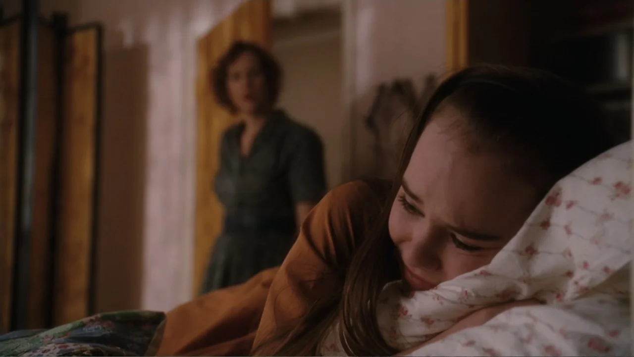 Flipped (2010) movie still: medium — A dimly lit residential bedroom features a bed with floral-patterned bedding and wooden furniture. A young girl…