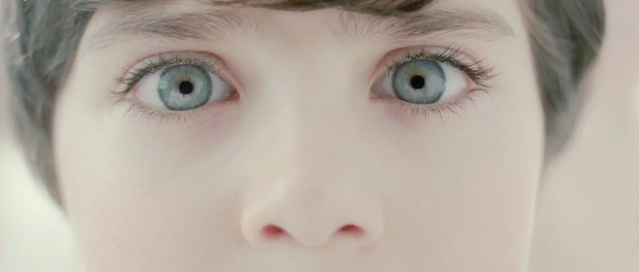 Mr. Nobody (2009) movie still: closeup — A close-up frame focuses entirely on the upper face and eyes of a child. The subject gazes directly forward…