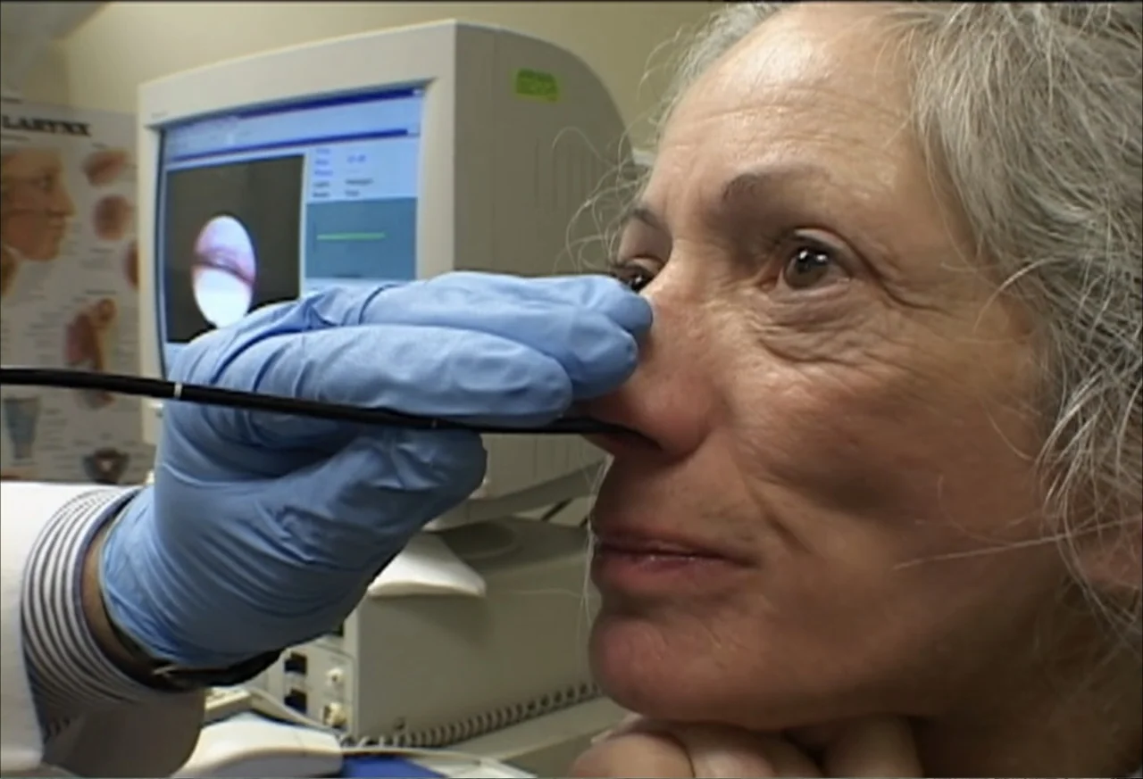 Plastic Disasters (2006) movie still: closeup — A clinical examination room features a computer monitor displaying an endoscopic image. A medical…
