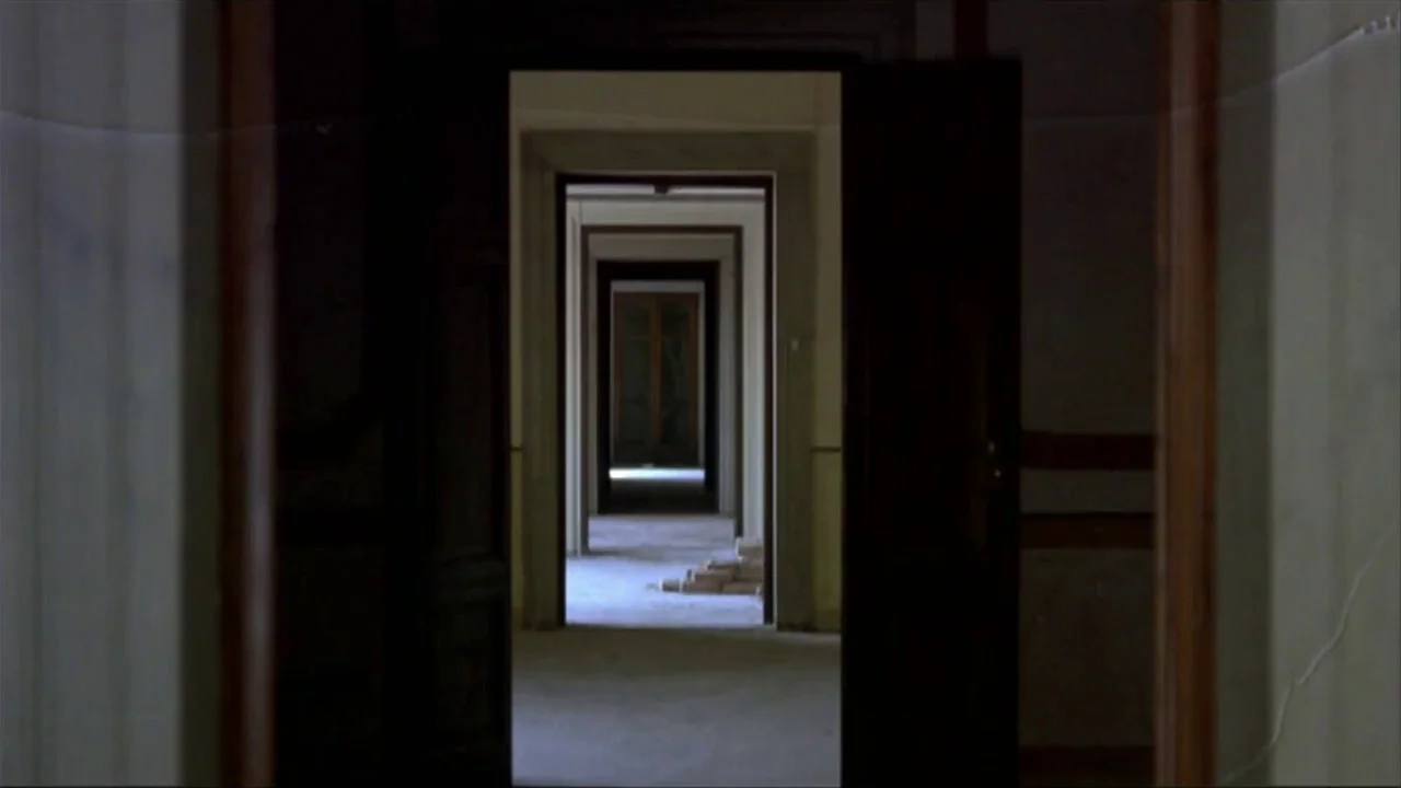A Quiet Place In The Country (1968) movie still: establishing — An interior hallway features a series of aligned open doorways forming a long…
