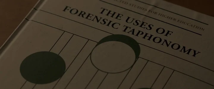 To Dust - Nightmares (2018) movie still: closeup — A close-up of a book cover titled The Uses of Forensic Taphonomy. The cover has a white…