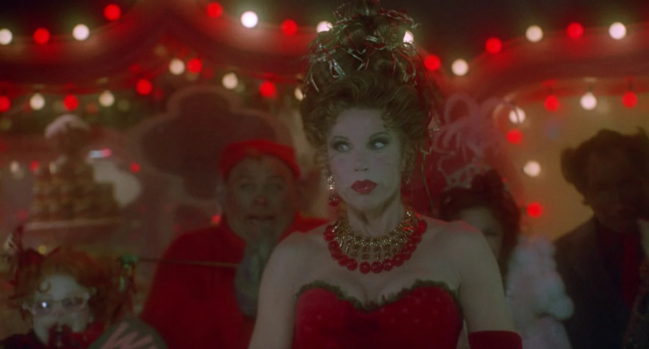 How The Grinch Stole Christmas (2000) movie still: medium — A festive circus tent interior features a woman in an elaborate red costume. Blurred…