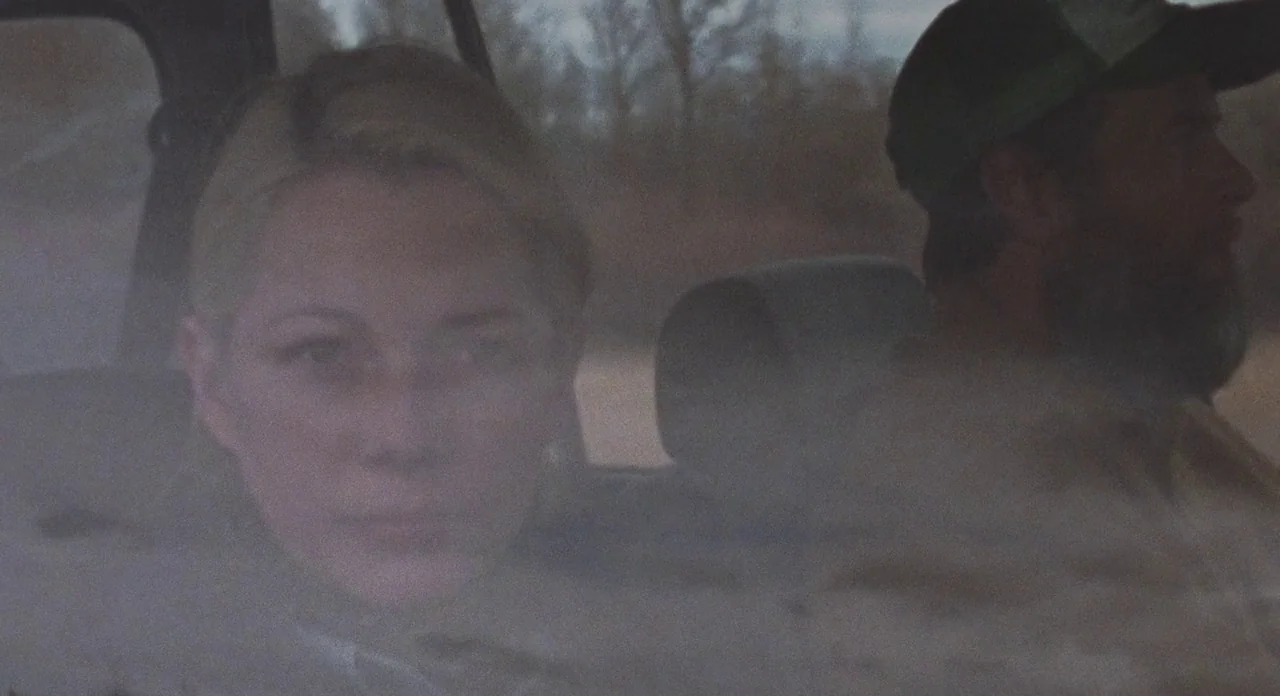 Certain Women (2016) movie still: medium — The interior of a moving vehicle with a woman and a bearded man. They are traveling through a landscape…