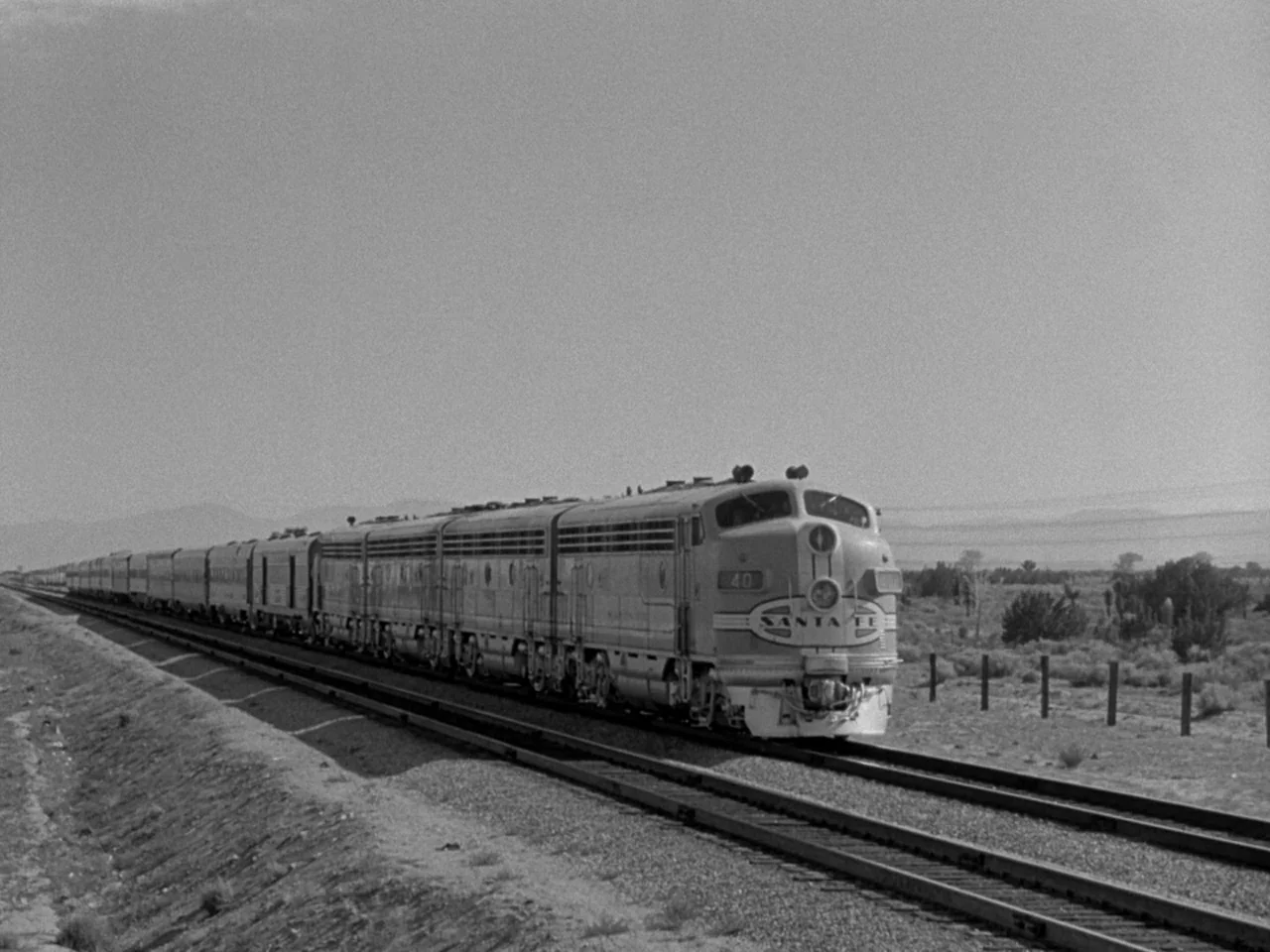The Day the Earth Stood Still (1951) movie still: wide — A Santa Fe passenger train moves across a vast, arid desert environment under bright skies.…