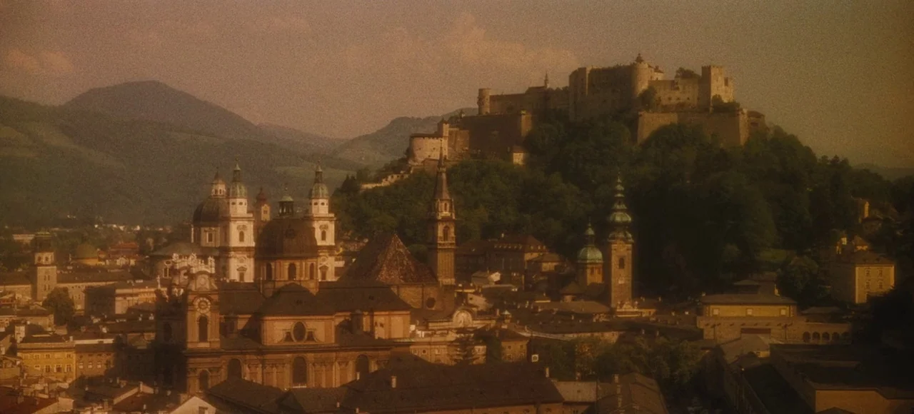 The Sound of Music (1965) movie still: establishing — An aerial view of an Austrian city featuring multiple church domes and rooftops. A large…
