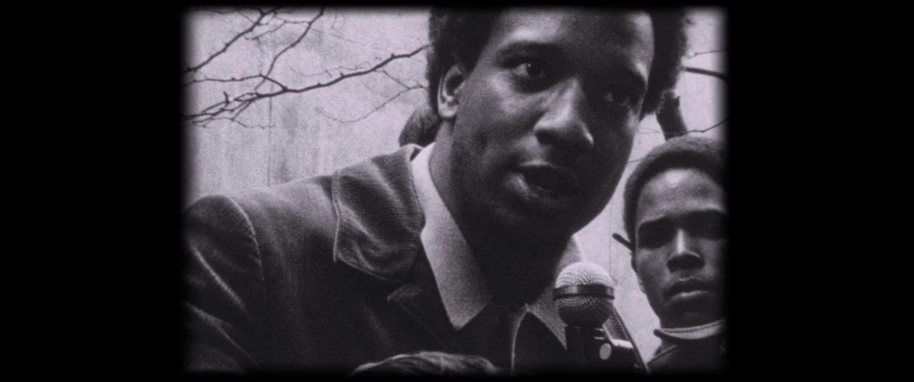 Judas and the Black Messiah (2021) movie still: medium — An outdoor urban environment featuring bare tree branches against a pale backdrop. A young…