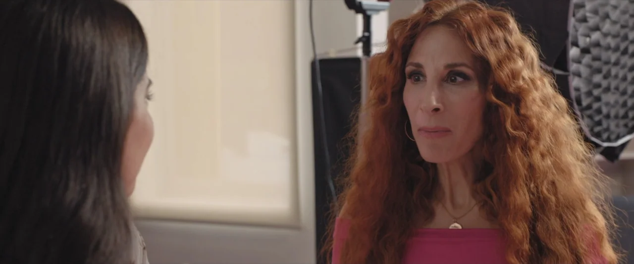 Like or Die (2023) movie still: medium — A bright indoor office space features neutral walls and professional equipment in the background. A woman…