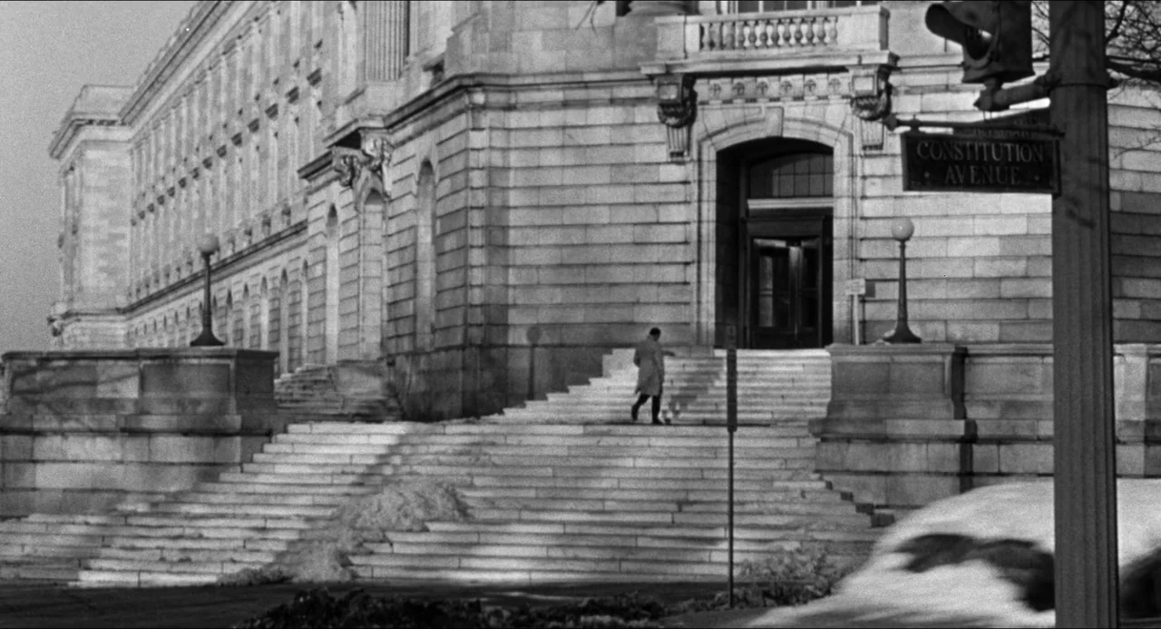 The Fearmakers (1958) movie still: wide — A massive classical stone government building features wide exterior stairs leading to a doorway. A man in…