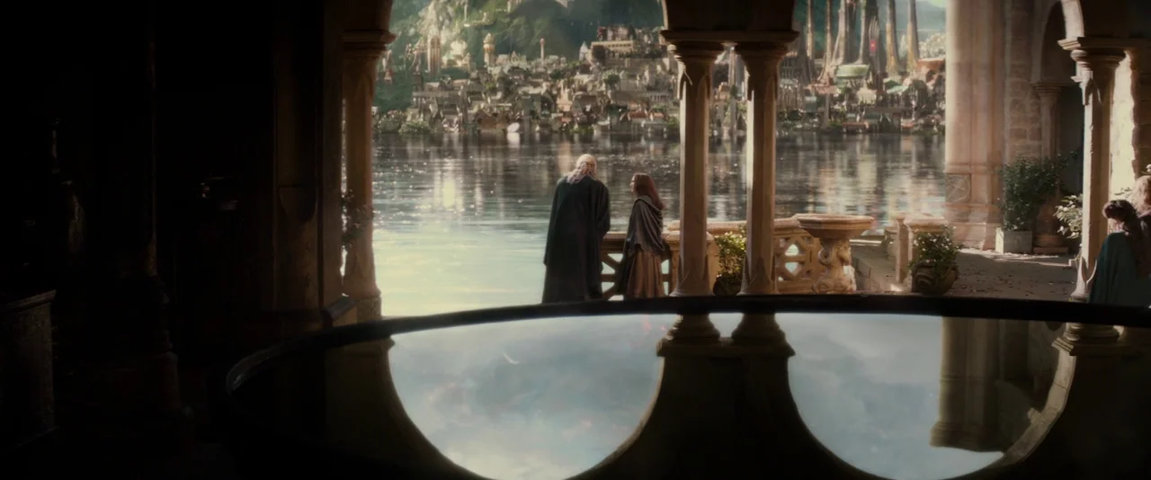 Thor: The Dark World (2013) movie still: wide — A stone balcony overlooks a wide body of water towards a distant elven city. Two figures stand by…