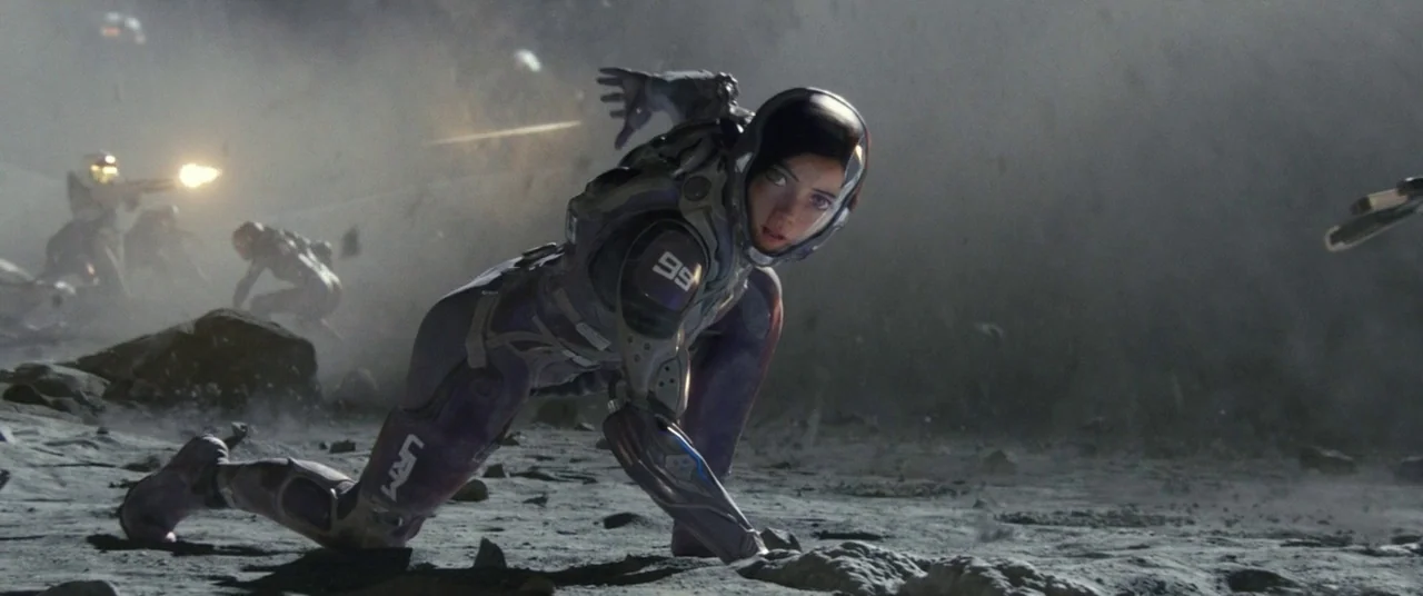 Alita: Battle Angel movie still: fullbody — A desolate, rocky plain covered in grey dust with debris scattered throughout the frame. A female…