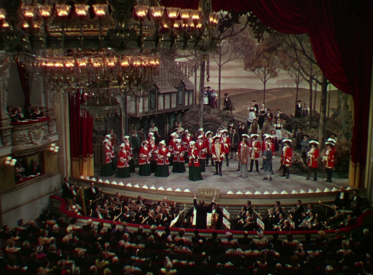 Phantom of the Opera (1943) movie still: establishing — A grand opera house features a crowded stage with actors in period military uniforms. The…