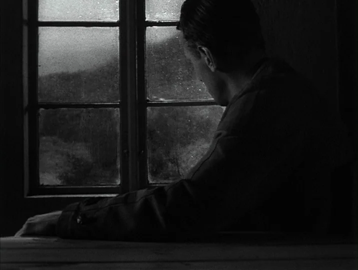 Hour of the Wolf (1968) movie still: medium — A dark, dimly lit room contains a single paneled window overlooking a distant landscape. A man sits by…