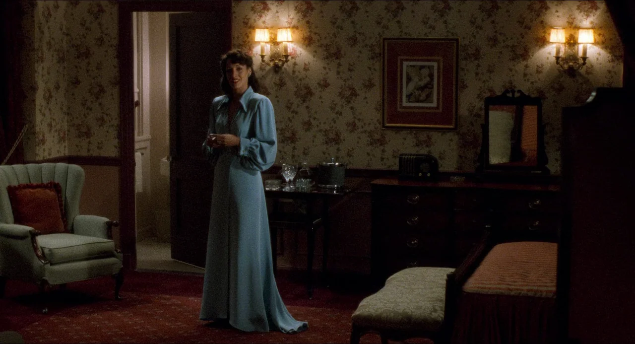 Devil In A Blue Dress (1995) movie still: fullbody — A hotel room with vintage floral wallpaper features ornate wood furniture and red carpeting. A…