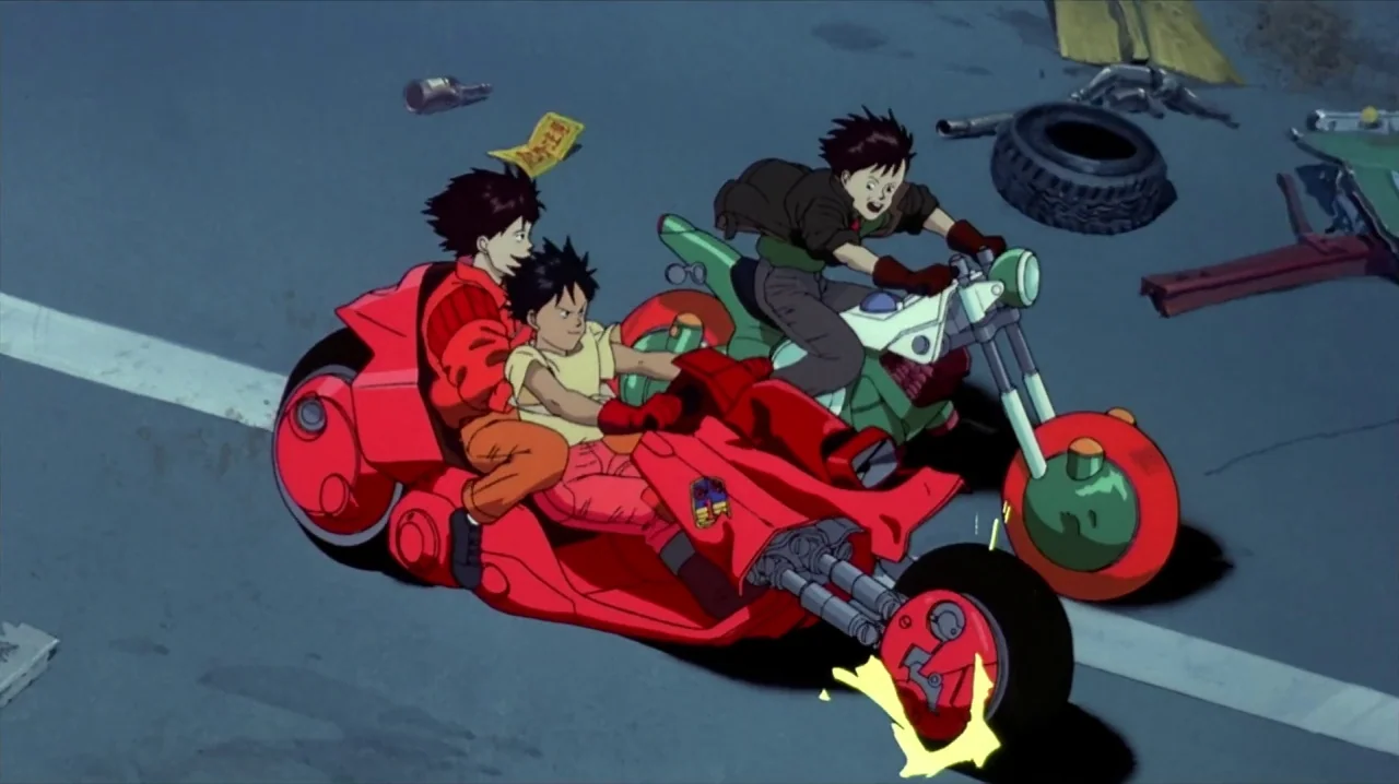 Akira (1988) movie still: wide — A dark paved expanse scattered with debris and a discarded tire under high-angle lighting. Three teenagers ride two…