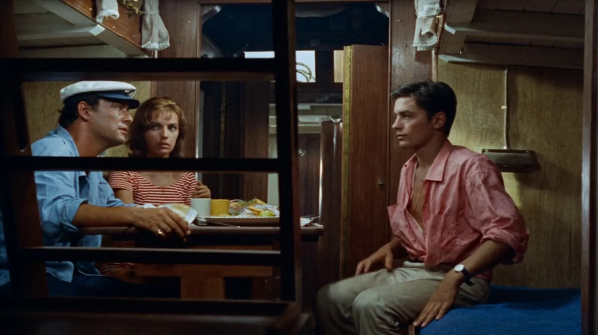 Purple Noon (Plein Soleil) (1960) movie still: medium — A wood-paneled cabin on a boat features a small table with mugs and food. Two men and a…