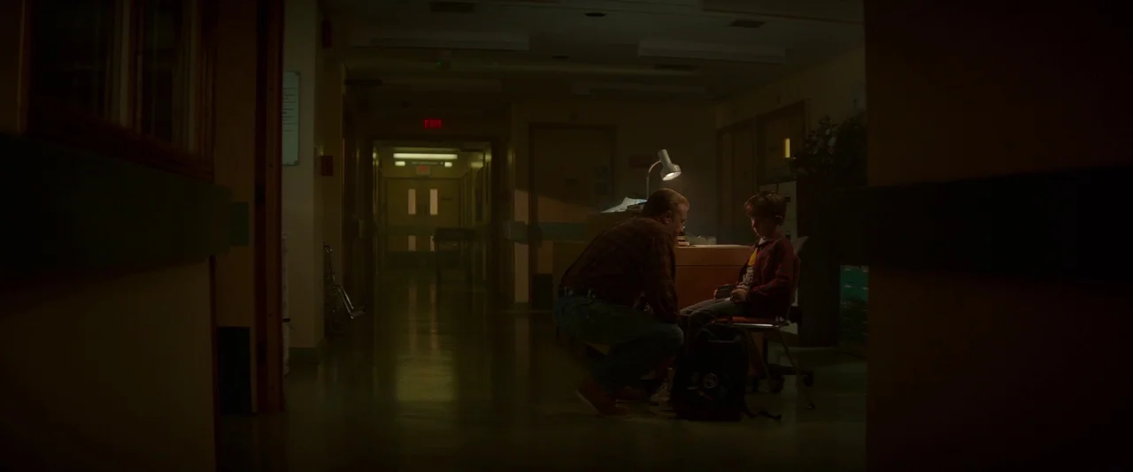 Guardians of the Galaxy (2014) movie still: wide — A dimly lit hospital corridor at night with linoleum flooring and muted green walls. A man kneels…