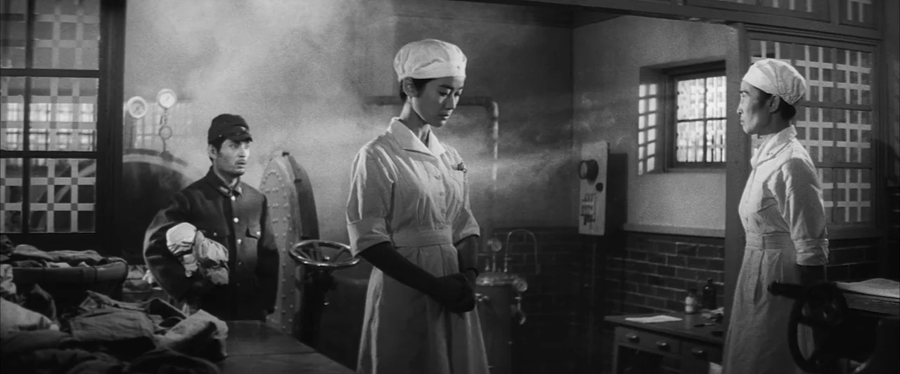 The Human Condition II: Road to Eternity (1959) movie still: fullbody — A steam-filled institutional space features brick walls, industrial piping,…