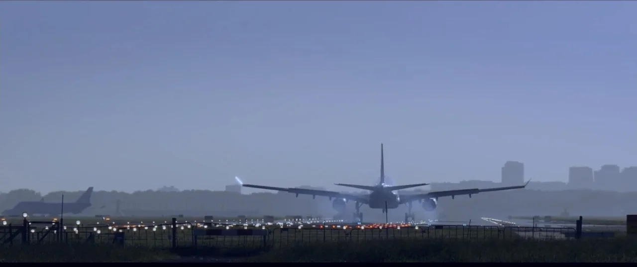 Room 6 (2006) movie still: wide — A passenger airplane lands on an airport runway against a soft blue morning sky. Distant city buildings are…