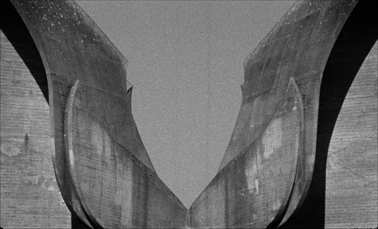 Last and First Men (2020) movie still: establishing — A brutalist concrete monument structure features sweeping, symmetrical curved walls rising…