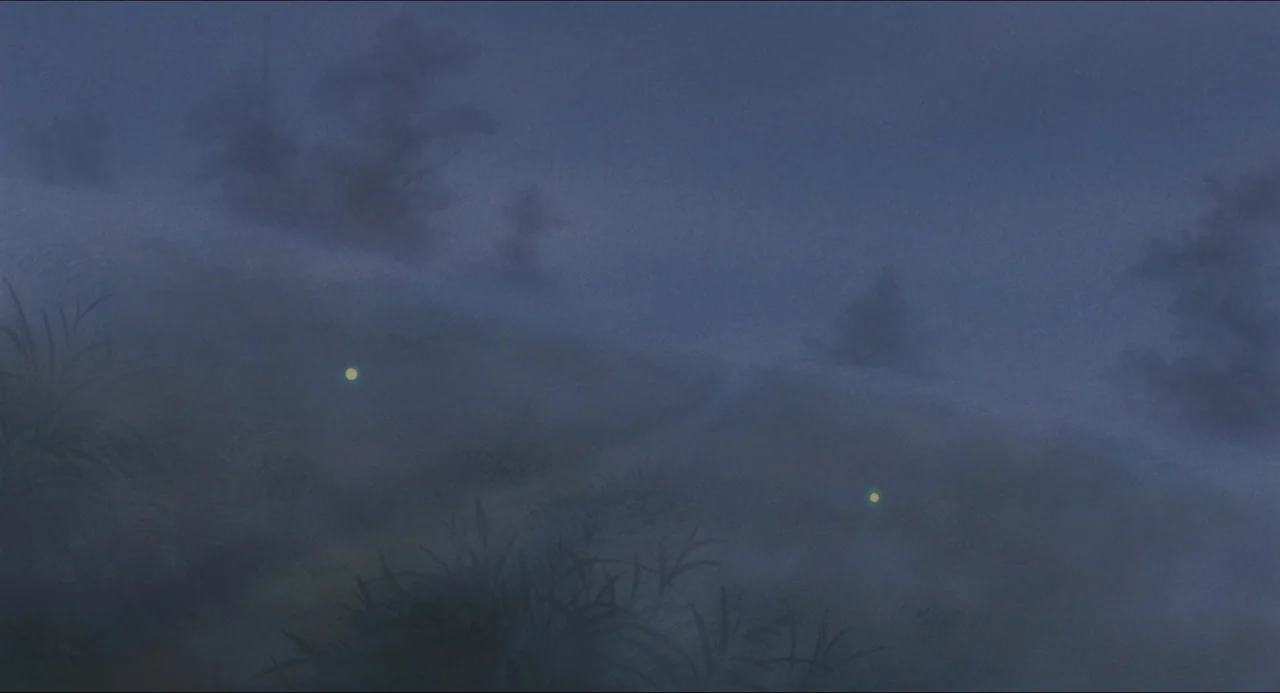 Grave of the Fireflies (1988) movie still: A tranquil, atmospheric wide shot captures a mysterious, foggy natural landscape at blue hour or night.…