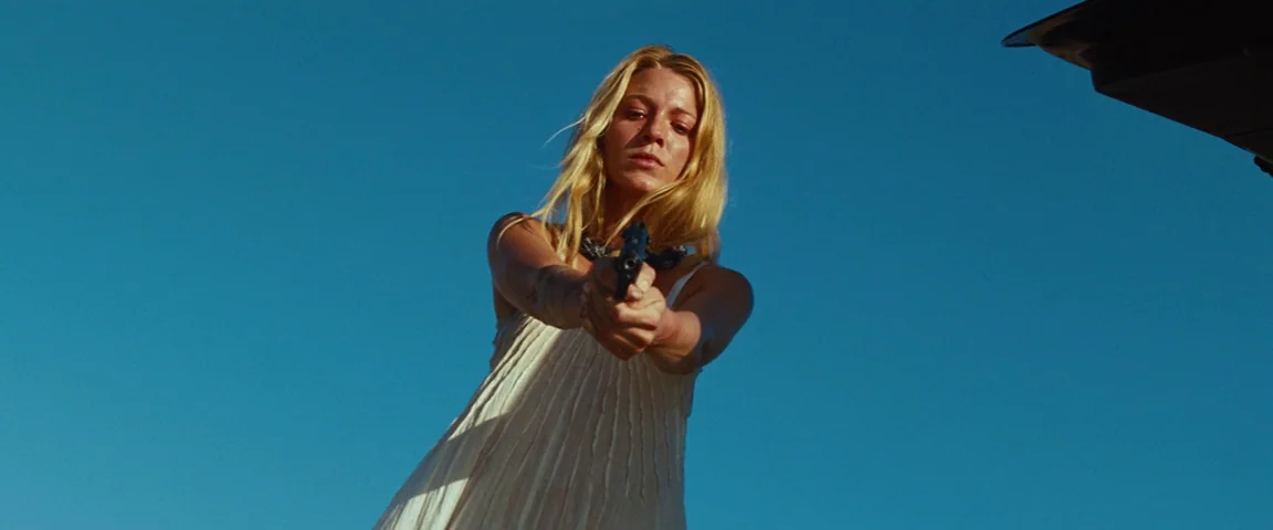 Savages (2012) movie still: medium — An open field under a clear blue sky serves as the backdrop for the subject. A blonde woman in a white dress…