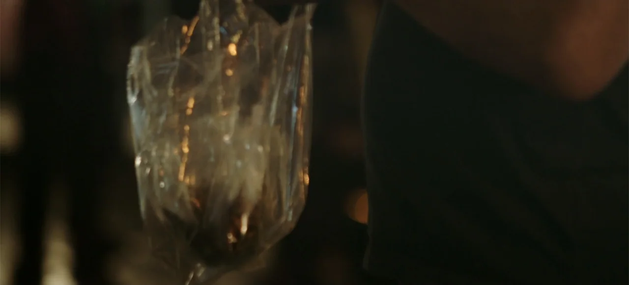 10 Billion: What's On Your Plate (2015) movie still: closeup — A close up view of a crumpled clear plastic bag held by an unseen hand. The…