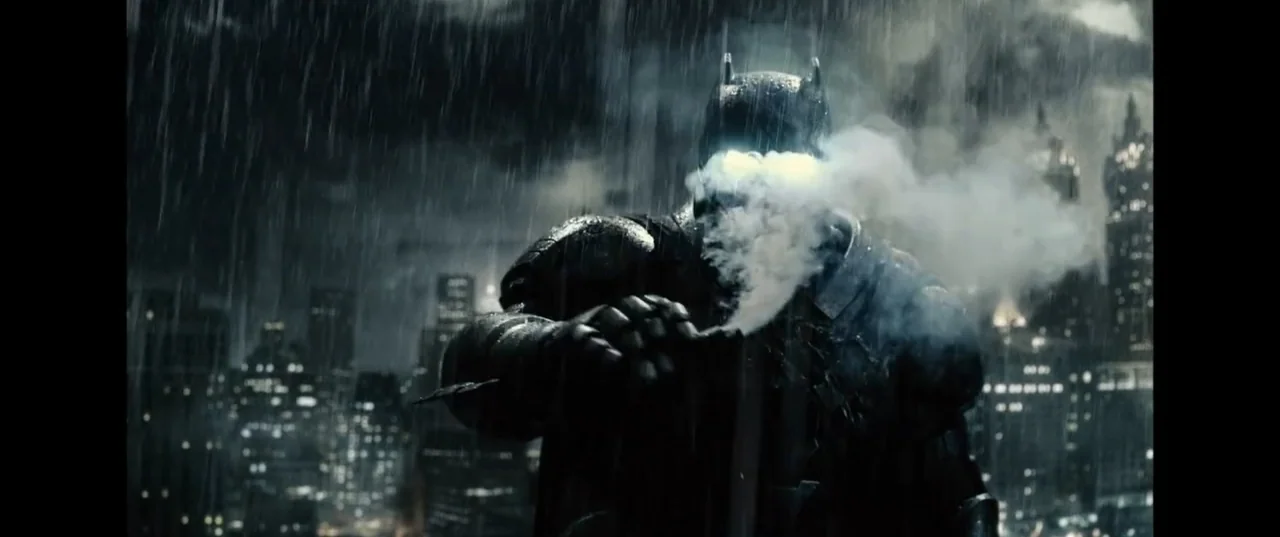 Batman v Superman: Dawn of Justice (2016) movie still: medium — A dark, rainy rooftop at night features blurred cityscape lights in the background.…