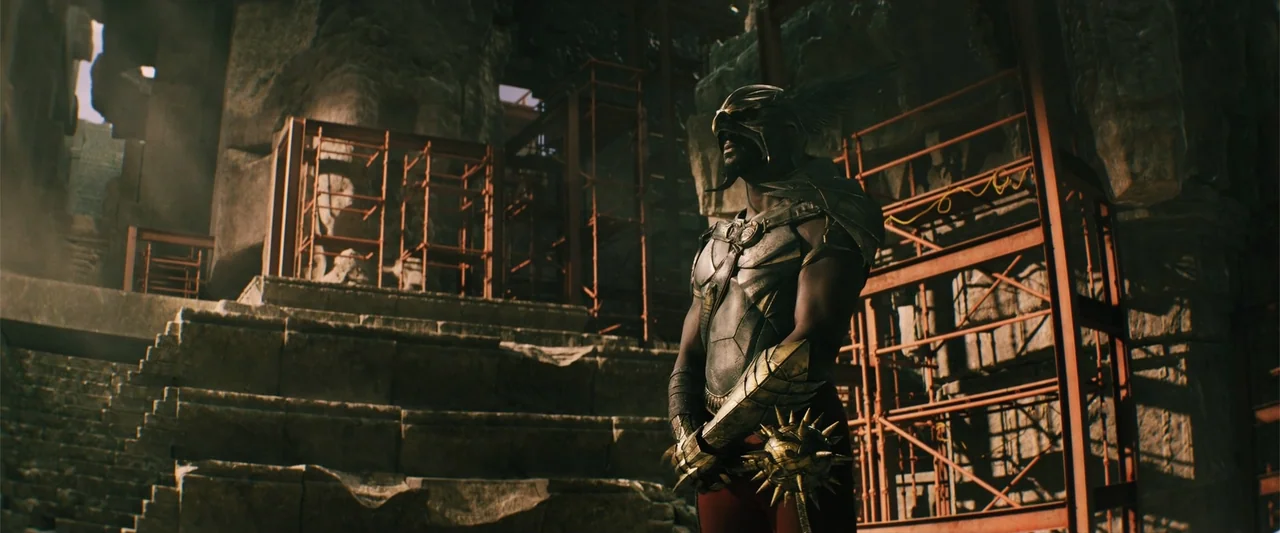 Black Adam (2022) movie still: medium — An ancient stone ruin structure under construction features red scaffolding against carved weathered rock…