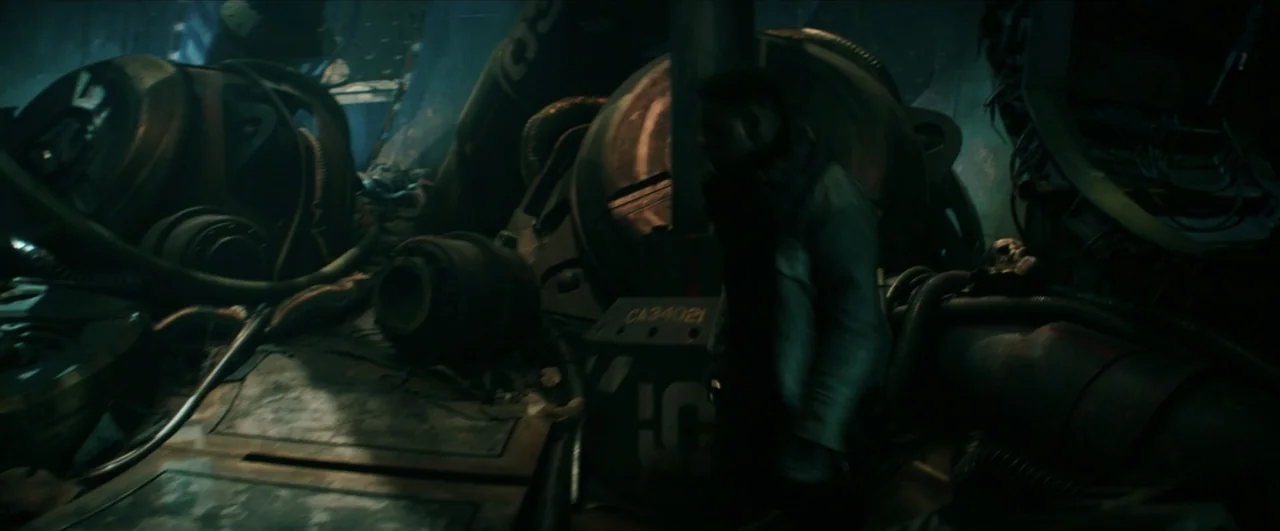 Pacific Rim: Uprising (2018) movie still: medium — A dark, cluttered industrial room filled with large mechanical machinery and thick metal piping.…