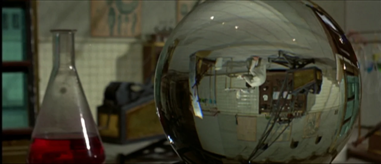 Flesh For Frankenstein (1973) movie still: closeup — A laboratory table features a glass flask containing red liquid and a spherical object. The…