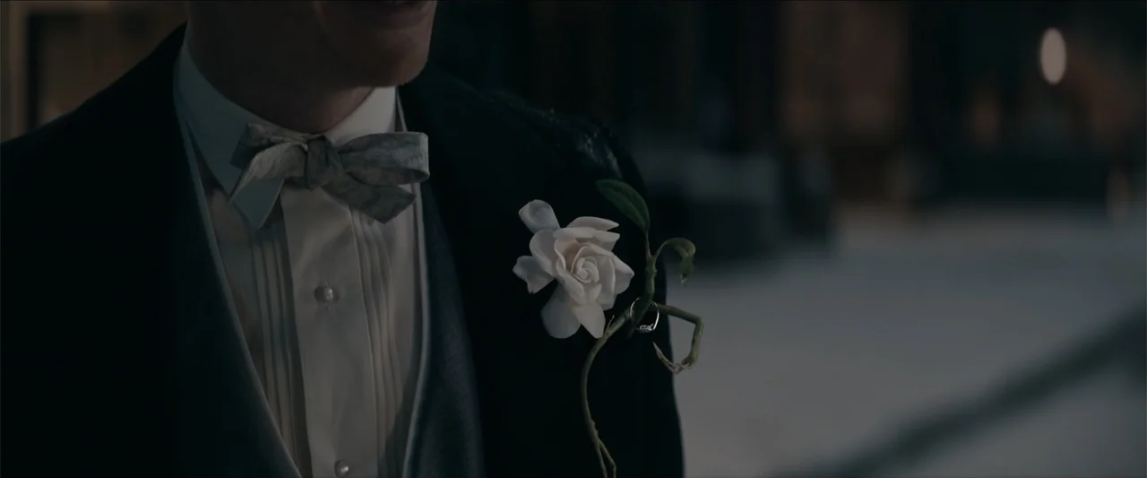 Fantastic Beasts and Where to Find Them (2016) movie still: medium — A dark outdoor space features a person wearing a formal tuxedo with a flower. A…