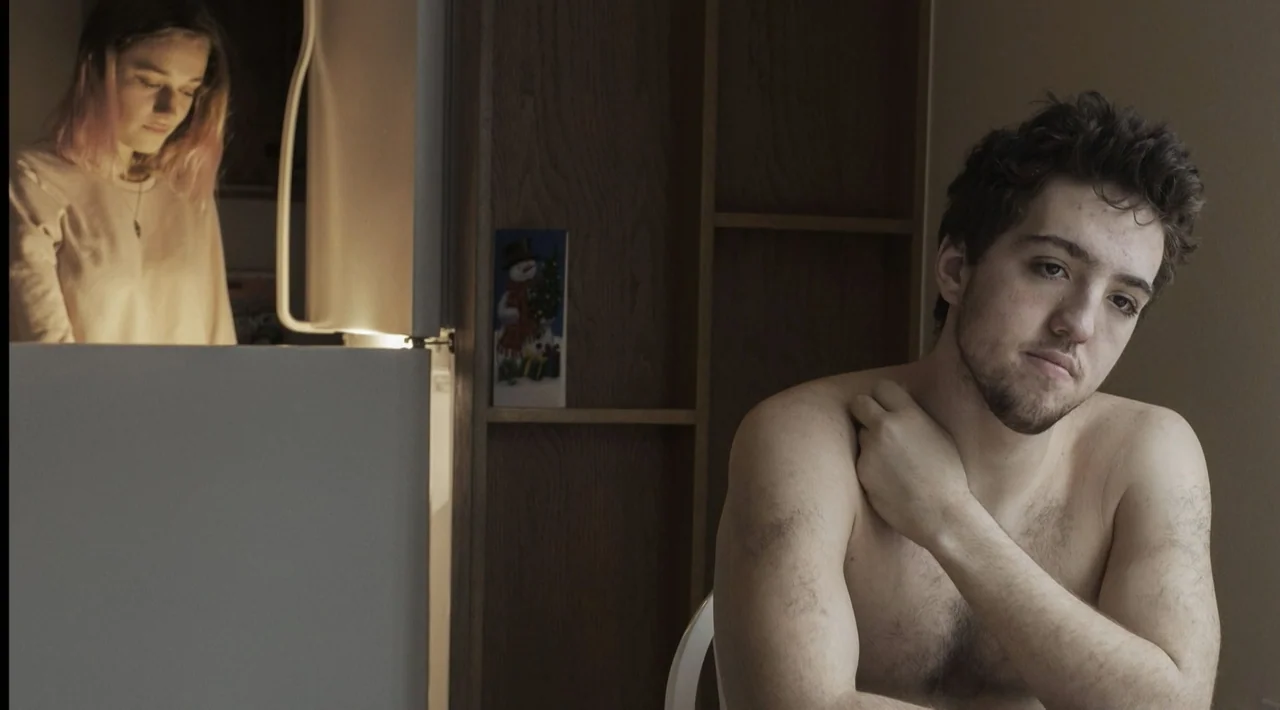 The Divided Soul of America (2019) movie still: medium — A domestic kitchen interior features a man in the foreground and a woman standing. The…