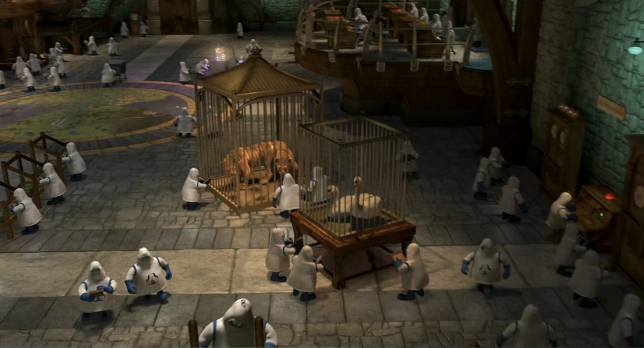 Shrek 2 (2004) movie still: wide — A stone-floored laboratory contains multiple metal cages holding various animals. Numerous small figures in white…