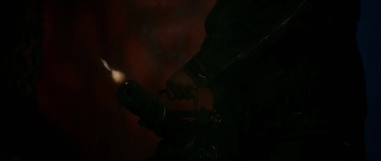 A Man Apart (2003) movie still: closeup — A dark, indistinct environment is momentarily illuminated by the flash of a weapon. A handheld rotary…