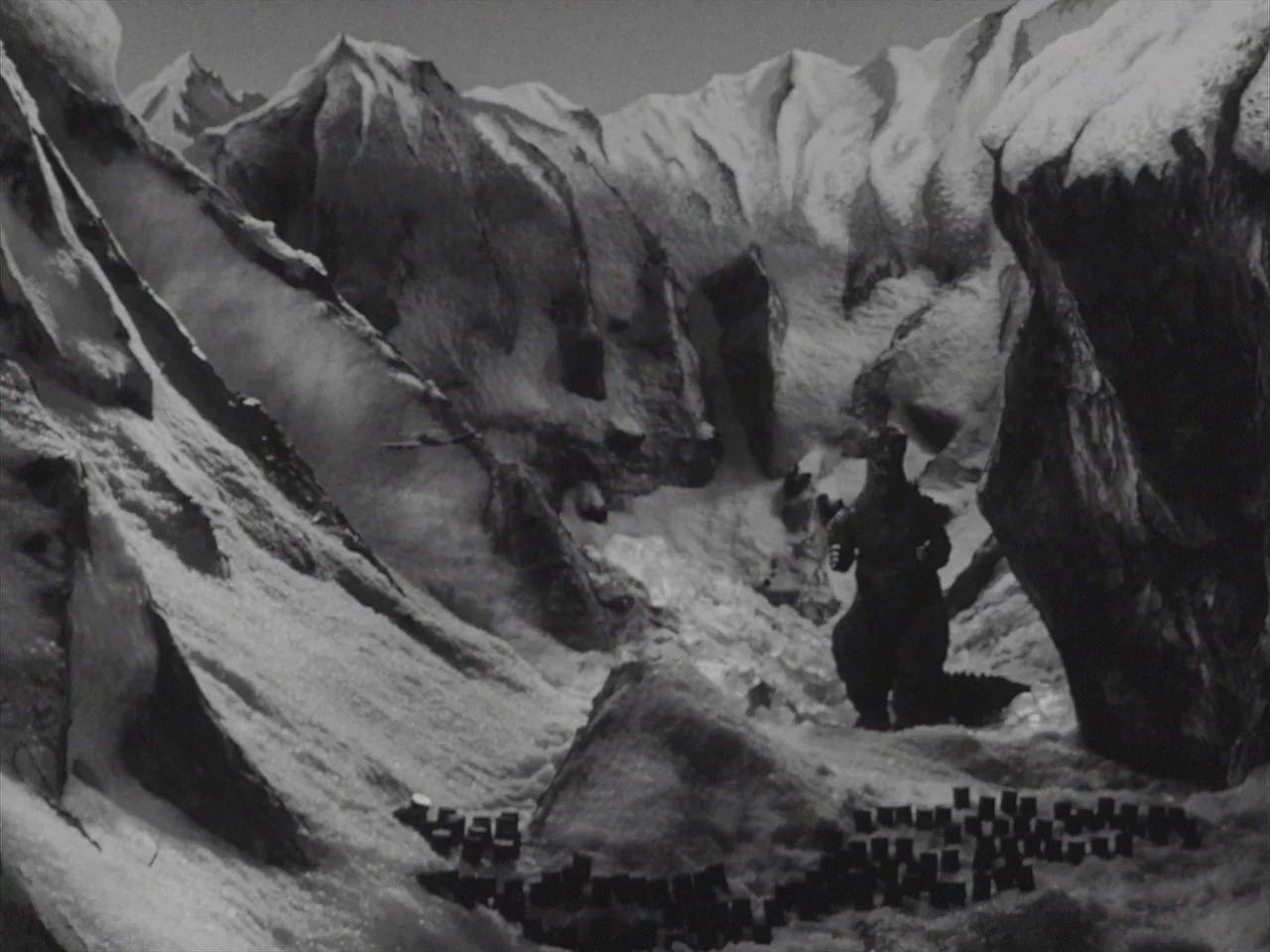 Godzilla Raids Again (1955) movie still: wide — A miniature model of a snowy mountain range features high peaks and deep ravines. A large dark…