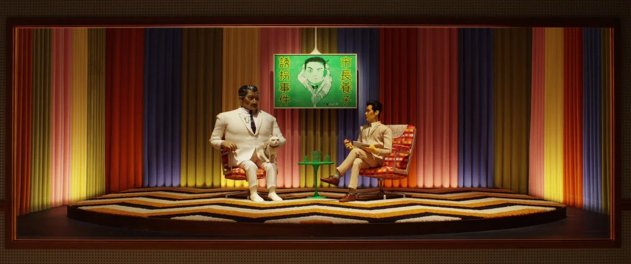 Isle of Dogs (2018) movie still: wide — A miniature television set with multi-colored curtains and a zig-zag patterned floor rug. Two stop-motion…