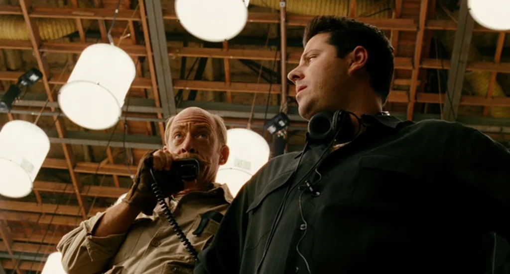 The Ladykillers (2004) movie still: medium — A high-ceilinged industrial space with exposed wooden beams and multiple large spherical light…
