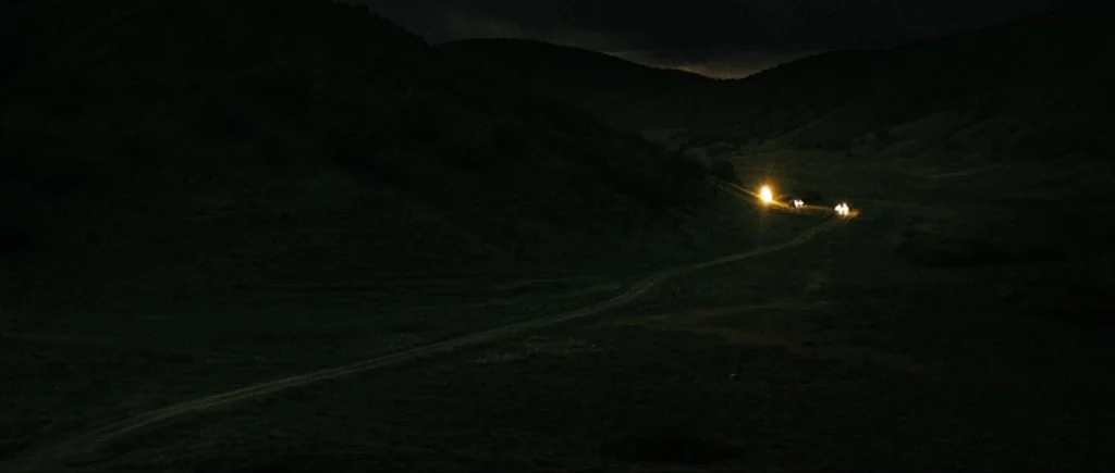 Once Upon a Time in Anatolia (2011) movie still: establishing — A dark, expansive valley is flanked by two large, shadowy hills at night. A lone…