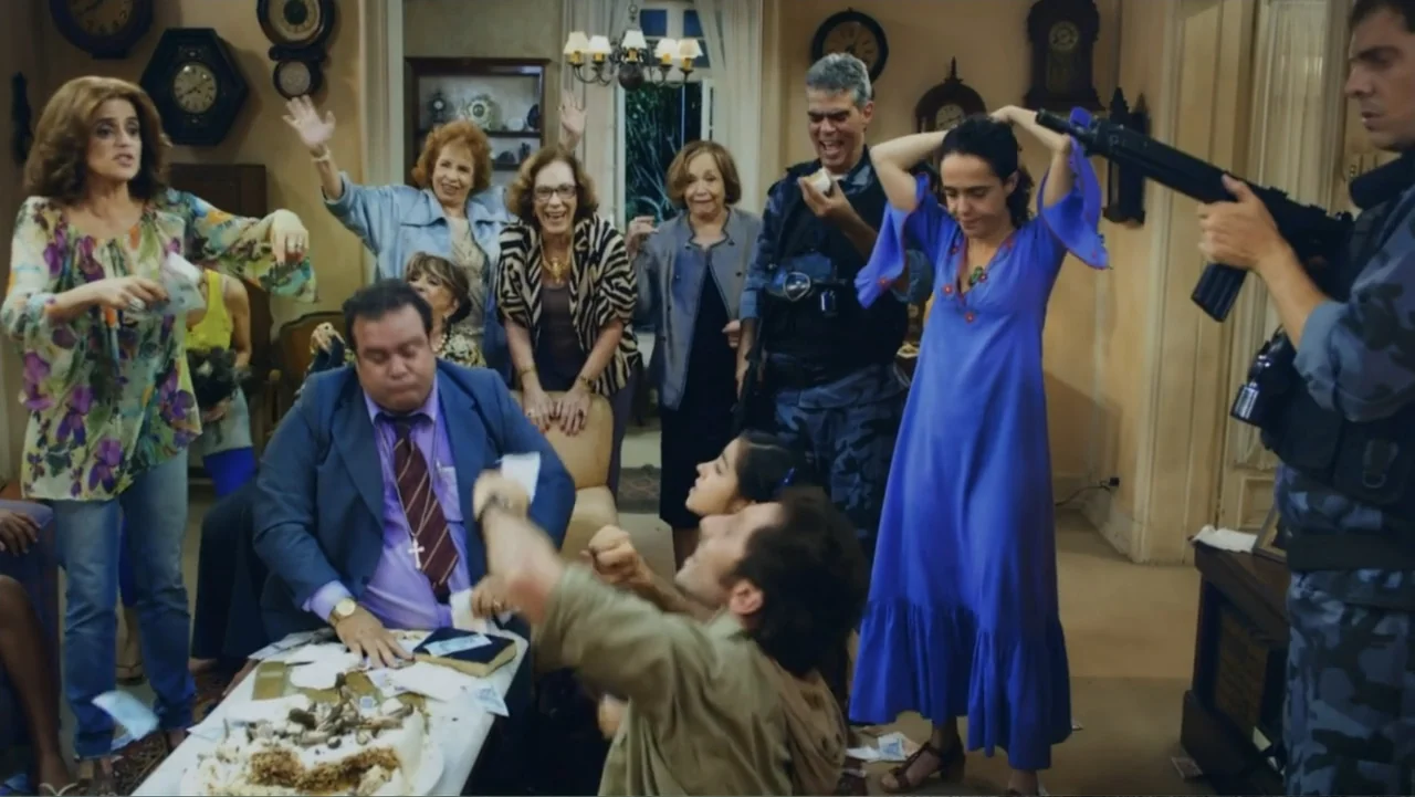 For Sale or Rent (2013) movie still: medium — A furnished interior room features various clocks on walls and a table with cake. A group of people…