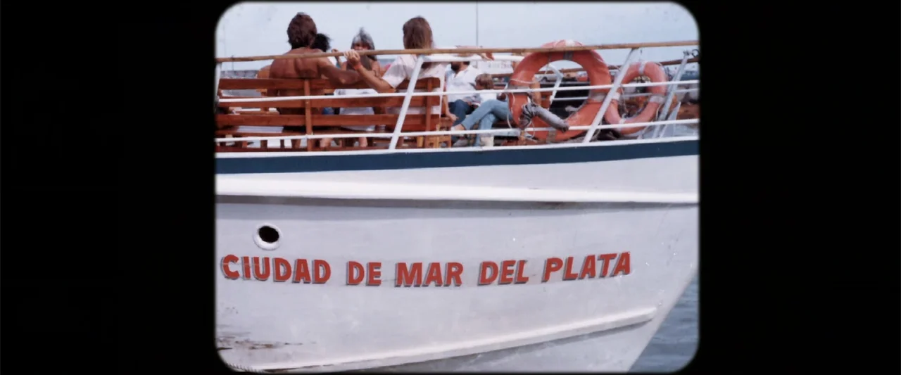 I Trust in You (2016) movie still: medium — A white boat with the text CIUDAD DE MAR DEL PLATA sits on water. Several people sit on wooden benches…
