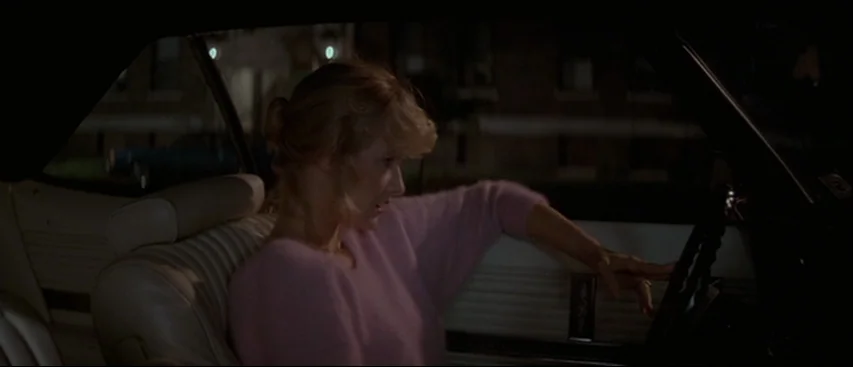 Blue Velvet (1986) movie still: medium — The interior of a vintage car at night is dimly illuminated from outside. A young woman sits in the…
