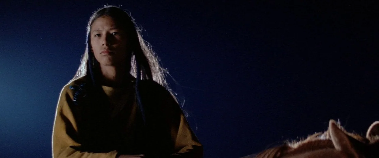 Dances With Wolves (1990) movie still: medium — A person is on a horse against a completely dark night sky. The subject appears at night illuminated…