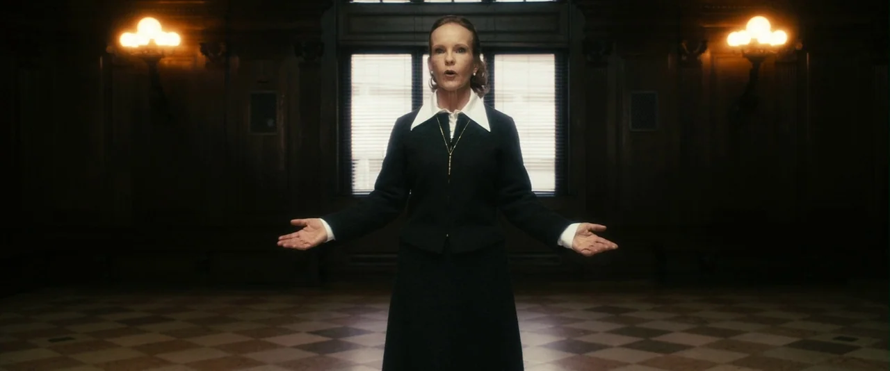 The Box (2009) movie still: fullbody — A dark, wood-paneled room features a checkered marble floor and a central window with blinds. A woman in a…