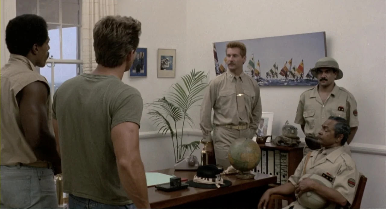 American Ninja 2: The Confrontation (1987) movie still: medium — A light-walled office contains a wooden desk, a globe, and framed pictures on the…