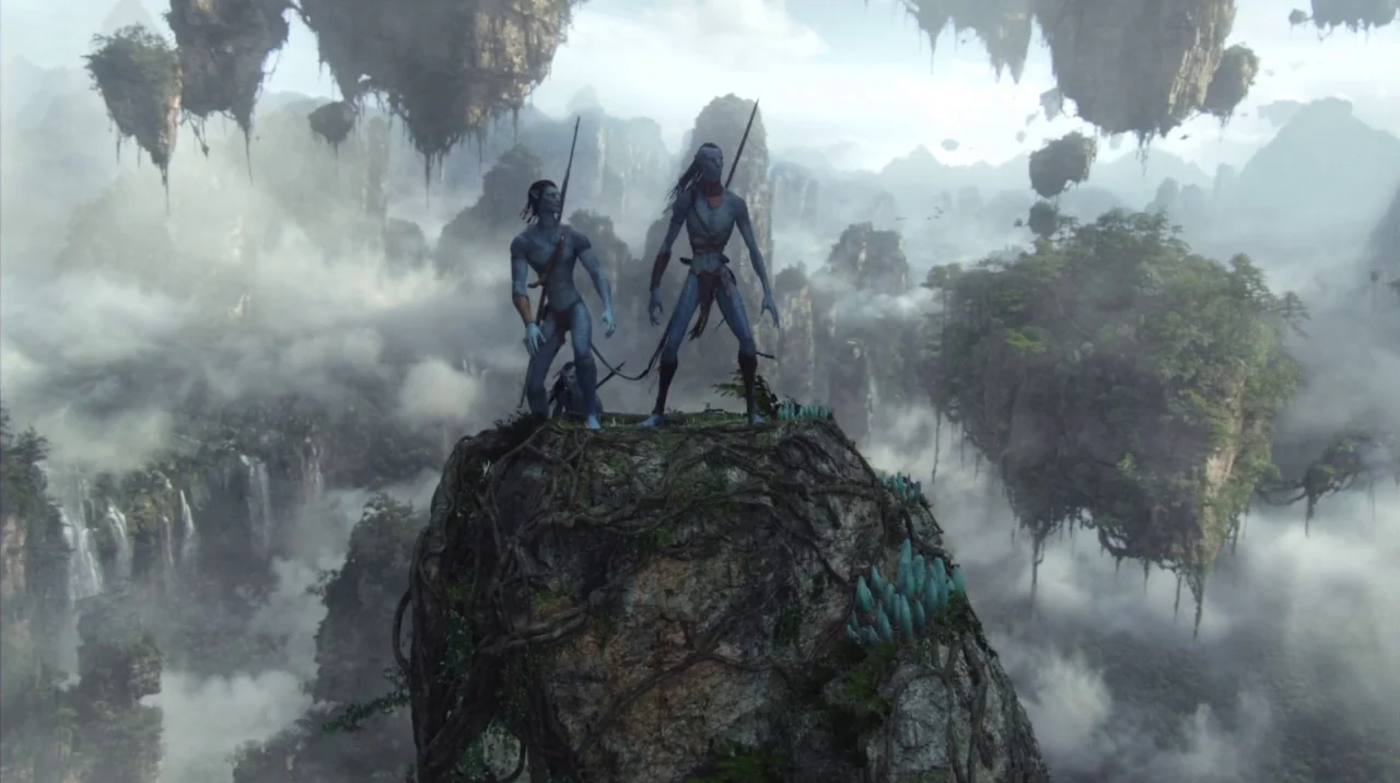 Avatar (2009) movie still: wide — A craggy rock pinnacle floats in a dense layer of thick white clouds. Two tall blue humanoid figures stand on the…